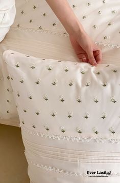 a person is holding onto a white pillow