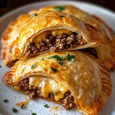 two pastries on a white plate topped with ground beef and cheesy cheese