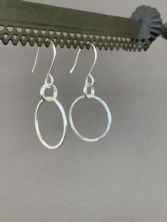 "Hand Forged Metal Jewelry | Silver Hoop Earrings, Fine Sterling Silver These round hoop earrings are perfect for everyday wear and would make a wonderful gift. We use only fine and sterling silver for all of our jewelry and findings, including our handmade earwires. Shaped and hammered for simplicity and elegance; then tumbled for strength and durability. Size is approximately 7/8\" x 1 7/8\". Our designs are each individually handcrafted and made to order.. because of this each design may have Minimalist Sterling Silver Oval Hoop Earrings, Small Hoop Sterling Silver Earrings With Lever Back, Oval Nickel-free Hoop Earrings For Everyday Wear, Nickel-free Oval Hoop Earrings For Everyday, Sterling Silver Hypoallergenic Hoop Earrings For Everyday, Everyday Oval Nickel-free Hoop Earrings, Everyday Small Silver Hoop Earrings, Everyday Hypoallergenic Sterling Silver Hoop Earrings, Nickel-free Hoop Earrings For Everyday