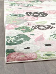 an area rug with flowers and circles on the floor in front of a wooden floor