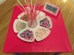 a table topped with lots of cupcakes covered in sprinkles and candy