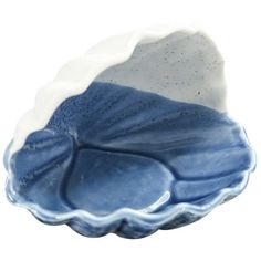 a blue and white dish on a white background with water droplets in the bottom half