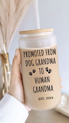 a person holding a glass with the words,'proud from dog grandma to human grandma est