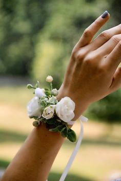 a woman's hand with a ring on it and flowers in the middle of her wrist