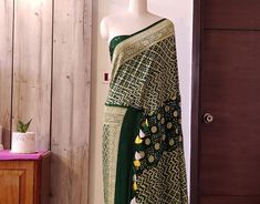 A spectacular Handwoven Deep Green Pure Banarasi Handloom Khaddi Georgette Bandhani Saree in gorgeous pattern. Its a fusion of karigari of Banarasi and Gujarati. Additional Information Color : Green Technique: Bandhani is a tye & dye technique in which fabric is pinched with nails and tied with thread and then dyed to create fabulous patterns. Fabric: Pure Georgette Blouse Piece: Included Since this product is handwoven, there might be slight irregularities. But doesn't that add to the singular Bohemian Pre-draped Saree With Zari Work For Festive Season, Festive Bohemian Pre-draped Saree With Zari Work, Festive Bohemian Pre-draped Saree With Cutdana, Green Fitted Bohemian Pre-draped Saree, Designer Transitional Pre-draped Saree With Bandhani Print, Festive Bohemian Pre-draped Saree With Pallu Feature, Festive Bohemian Pre-draped Saree With Pallu, Designer Green Bandhani Print Lehenga, Designer Green Pre-draped Saree With Motifs