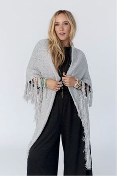 Drape yourself in the Moon Shadows Ruana Wrap and feel stylishly boho from day to night! This cozy-knit wrap features a loose and flowy silhouette, a beautiful triangular shape, and adorable tassel trim for a unique and versatile look. Infuse your wardrobe with some boho flair! Details: One size: 33 1/2"W x 86"L 100% Acrylic Hand wash cold, Lay flat to dry Import Ruana Wrap, Three Bird Nest, Moon Shadow, In The Moon, Knit Wrap, Beach Inspired, Cozy Knits, The Moon, Black And Grey