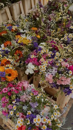 many different types of flowers in wooden crates