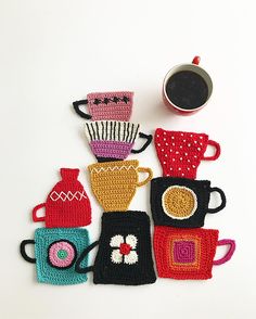 crocheted coasters with coffee cups and teapots on them, sitting next to a cup of coffee