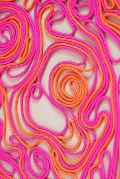 an orange and pink piece of fabric with swirls on it