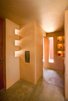 Gorgeous modern home architecture with cutout windows creates shadows & natural light against orange earth toned adobe stucco interior. Modern Home Architecture, Corner Lighting, Windows Frame, Front Door Entry, Home Front Door