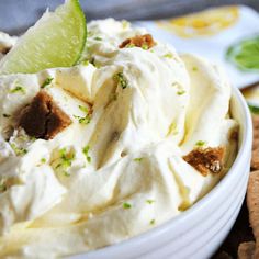 a close up of a bowl of food with a lime wedge on the side and crackers