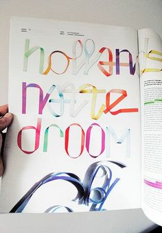 a person is holding an open book with colorful letters