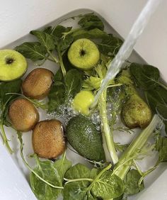 fresh fruits and vegetables being washed in a sink