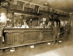 two men in suits are standing at the bar