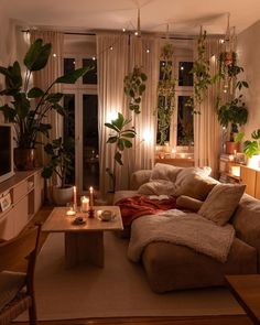 a living room filled with lots of furniture next to a window covered in plants and candles