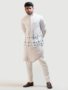 This Cream Phulkari Nehru Kurta Set will instantly give an elegant look. This 3 piece kurta set features a linen satin cream kurta with overlapping silhouette, high and low panels, stitch line borders, and motif embroidery. A Nehru jacket enhanced with Phulkari stitch details, pipe work embroidery, invisible front button placket, and a mandarin collar. It is paired with narrow fitted pajama pants in cream color and malai cotton fabric. An ideal outfit for traditional occasions, and special event Nehru Jacket For Men, Phulkari Embroidery, Mens Kurta Designs, Wedding Dress Men, Nehru Jacket, Silk Kurta, Mens Casual Dress Outfits, Stitch Lines, Embroidered Collars