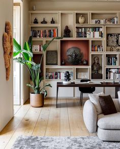 a living room filled with lots of bookshelves next to a couch and table