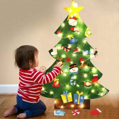 a small child playing with a christmas tree