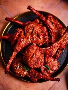 some meat is on a black plate and it looks like they have been cooked in the oven