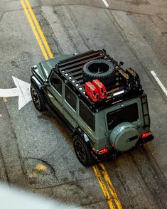 an off - road vehicle is parked on the side of the road with luggage strapped to it's roof