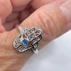 *  Sterling Silver Hamsa Tiny Blue Sapphire CZ Ring, Hand of God Ring, Religious Ring, Hamsa Promise Ring, Silver Ring, Statement Ring, Love Ring, Boho Ring, Eye Ring, 925 Stamped *  Hamsa is primarily used to protect its owner from the Ayin Ha'ra also known as The Evil Eye Protective talisman that brings good fortune, health and happiness *  Perfect gift idea for any occasion: birthday, anniversary, engagement, graduation, bridesmaid, Mother's Day, Valentine's Day, Christmas, promise. *  Your p Spiritual Blue Crystal Ring, Adjustable Blue Birthstone Jewelry, Blue Gemstone Midi Promise Rings, Adjustable Blue Crystal Gemstone Ring, Blue Spiritual Open Ring Jewelry, Adjustable Blue Crystal Promise Ring, Adjustable Spiritual Sapphire Ring As Gift, Blue Adjustable Crystal Promise Ring, Spiritual Blue Open Ring Jewelry