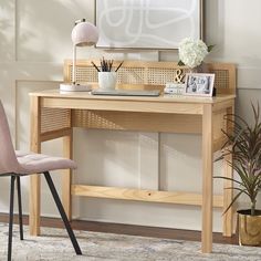 a wooden desk with a chair next to it and pictures on the wall behind it