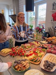 a woman standing in front of a table filled with food