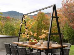 an outdoor dining table with chairs around it