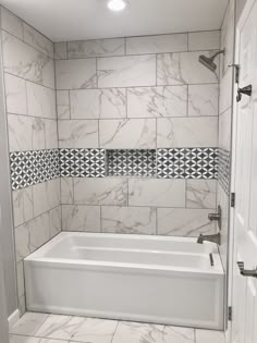 a white bath tub sitting inside of a bathroom next to a walk in shower door