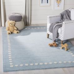 a child's room with a teddy bear and rocking chair on the floor in front of it