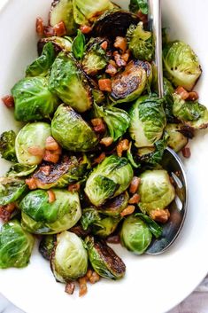 brussel sprouts in a white bowl with a spoon on the side