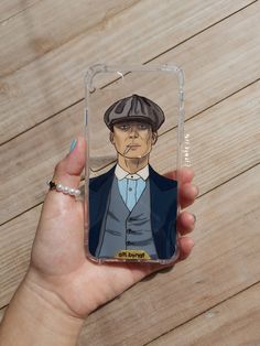 a person holding up a phone case with an image of a man in a suit and hat