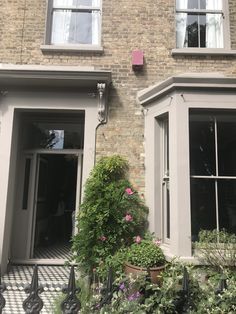 a brick building with many windows and plants