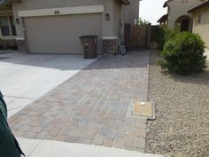 a house with a driveway in front of it and a trash can on the side