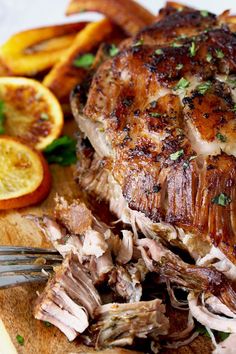 slow cooker cuban mojo pork on a cutting board with orange slices and parsley