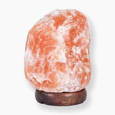 an orange rock sitting on top of a wooden stand