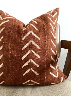 a brown and white pillow sitting on top of a chair