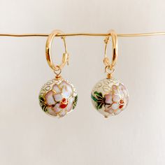 Add a unique touch to your look with our Floral Cloisonné Drop Hoop Earrings. These beautiful earrings feature rare cloisonné enamel beads, adding a playful pop of color to any outfit. Each pair is a wearable work of art, with subtle colors and removeable charms. A truly unique find! -- hoop diameter: 15mm and 19mm latch back cloisonné charms: 14mm and 18mm 14k Gold Filled available in white and black The ancient technique of cloisonné enamelwork is over 3,000 years old. Small Hoop Enamel Earrings For Gift, Small Hoop Enamel Earrings Gift, Enamel Clip-on Earrings As Gift, Enamel Small Hoop Earrings For Gift, White Enamel Hoop Earrings For Gifts, Small Hoop Enamel Earrings, Single Enamel Drop Earring, Enamel Ear Wire Jewelry, White Enamel Small Hoop Earrings