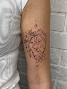 a woman's arm with a tattoo of a lion and flowers on the side