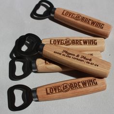 four wooden wine openers with love and brewing engraved on the handles, sitting next to each other