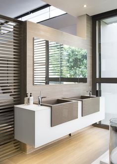 a modern bathroom with two sinks and large windows