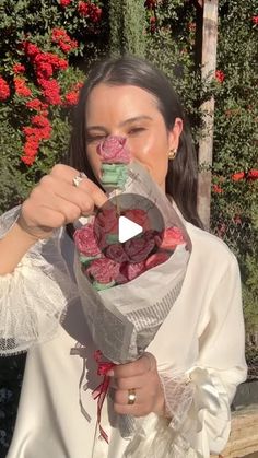 a woman holding a bouquet of flowers in front of her face