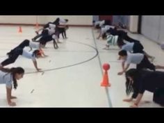 a group of people doing tricks on skateboards in an indoor gym area with orange cones