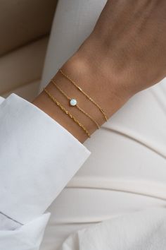 "This solitaire opal bracelet is a sweet and dainty addition to your jewelry collection! It's minimalist design makes it great for stacking, but also looks great on its own! -  -  - D E T A I L S - - - * Made of 925 Sterling Silver * THICK plating of 14k Gold or Rhodium  * 6.25\", 6.75\" , or 7\" + .5\" Ext Lengths available  * Lan created opal stone is made of highest grade of quality for an authentic look! * Nickel-free & Hypoallergenic  * 5mm Opal Stone Bracelets on Model: Turquoise Tennis Bracelet: https://www.etsy.com/listing/1050935357/turquoise-bracelet-turquoise-tennis?click_key=a1a1e3ea13ccfb6cdba3a13472c1aa26c481fdb5%3A1050935357&click_sum=f47583dc&ref=shop_home_feat_2&pro=1 Opal Bracelet: https://www.etsy.com/listing/1063792532/opal-bracelet-white-opal-bracelet?click_key=bc44a7a Minimalist Everyday Opal Jewelry, Elegant Adjustable Opal Beaded Bracelets, Elegant Opal Beaded Bracelets As Gift, Minimalist Opal Jewelry With Delicate Chain, Dainty Adjustable Opal Bracelet, Minimalist White Bracelet With Delicate Chain, White Dainty Bracelet With Delicate Chain, Sage Christmas, White Opal Bracelet