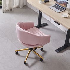 a pink chair sitting in front of a desk with a laptop on top of it