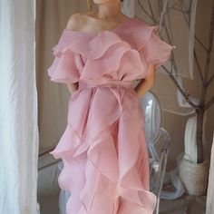 a mannequin wearing a pink dress with ruffles