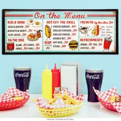 an image of fast food menu on the menu wall hanging above table with fries, ketchup, and french fries