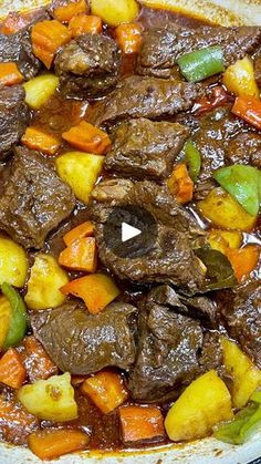 beef stew with vegetables and potatoes in a white bowl