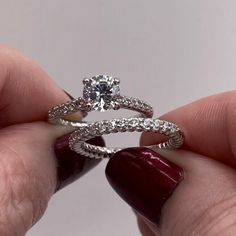 a person holding a diamond ring in their hand with the other hand on top of it