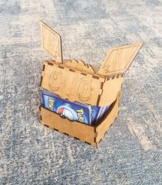 an open cardboard box with toothpaste in it on the floor next to carpet